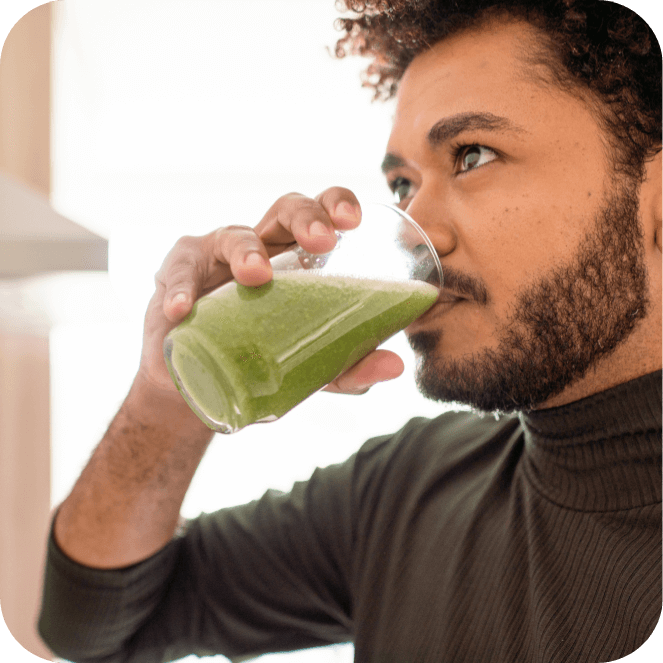 A man drinking a green smoothy